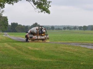 Dustkill applicator distributing treatment formula to a dirt road.